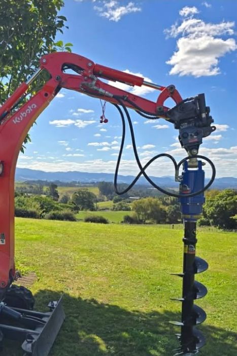 Excavatrice Kubota U17 équipée d'une tarière hydraulique pour le forage de trous destinés aux clôtures, pieux et poteaux.